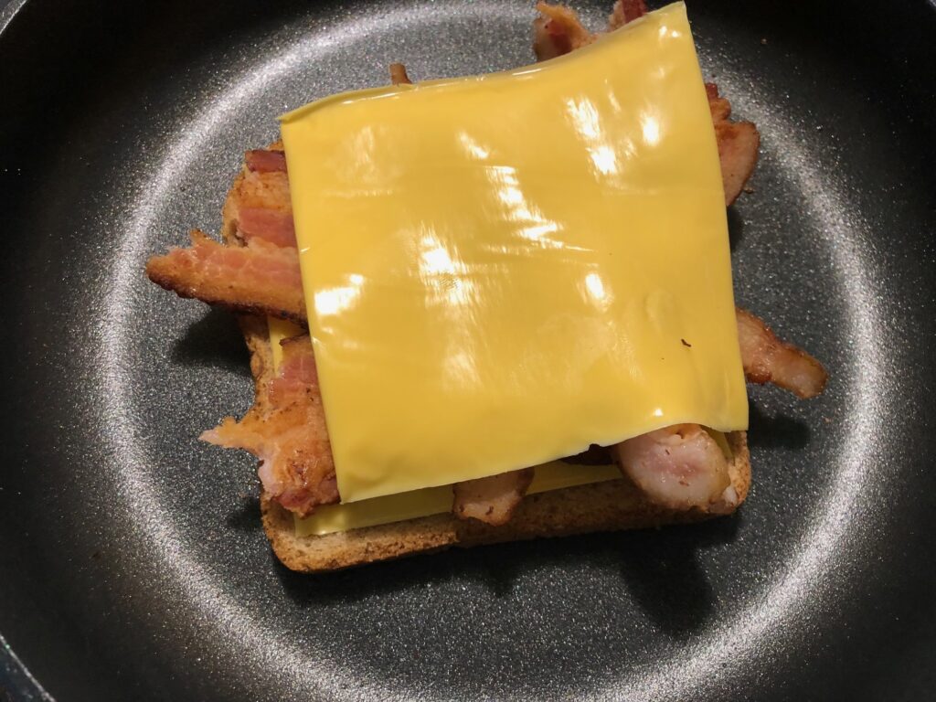 Add a layer of cheese, bacon, and another layer of cheese